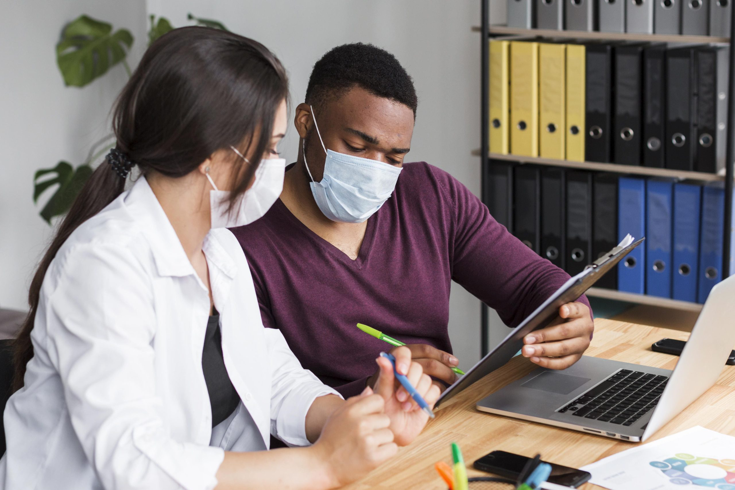 two-workers-office-pandemic-wearing-medical-masks-1-scaled